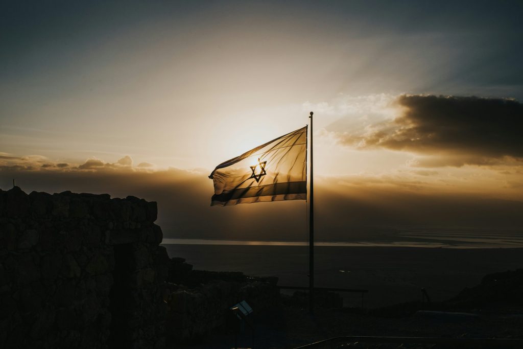 Gaza envelope tour memorial journey with Israeli flag silhouette at sunset over southern Israel
