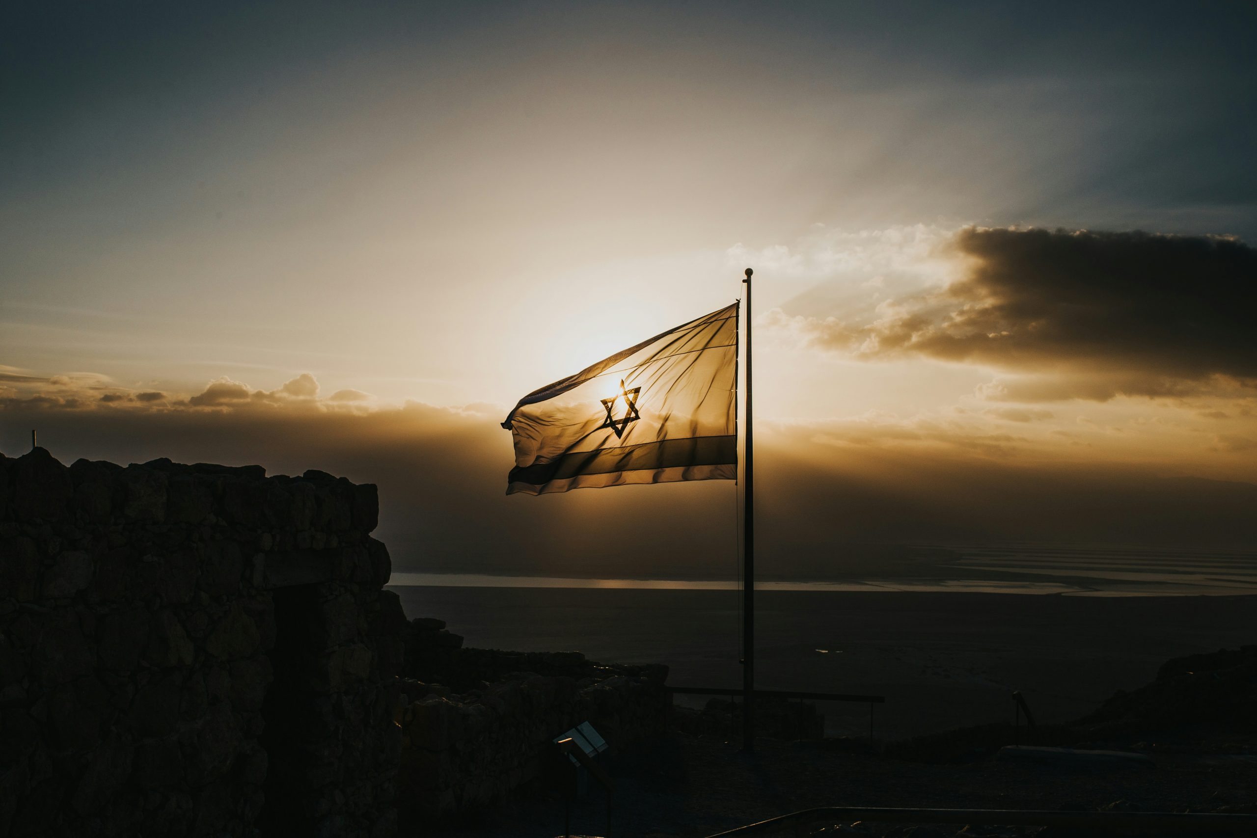 Gaza envelope tour memorial journey with Israeli flag silhouette at sunset over southern Israel