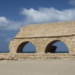 The ancient Roman aqueduct of Caesarea Maritima running along the Mediterranean beach in Israel