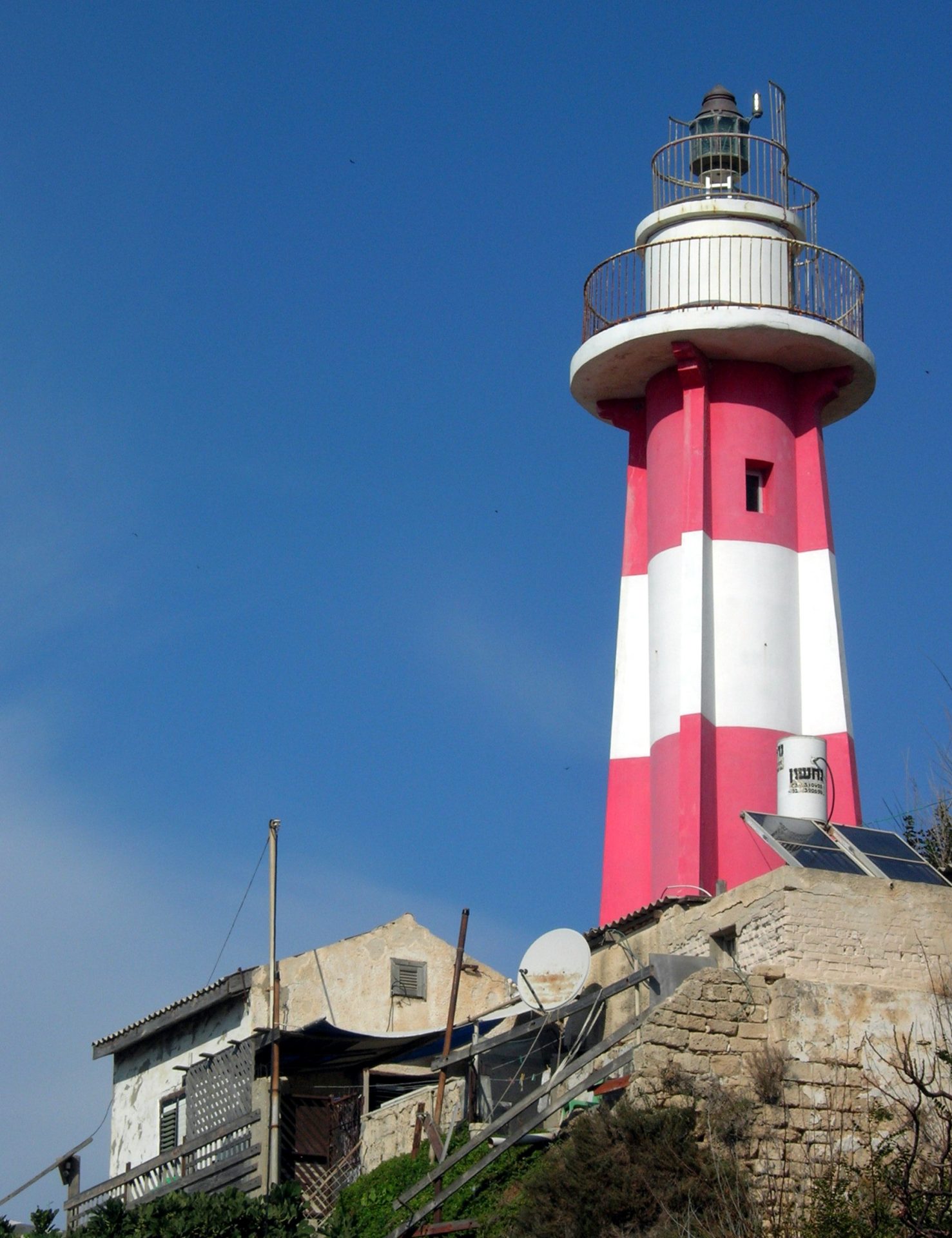 A narrow stone alley and the lighthouse in the old town of Jaffa, Israel, with artist studios and galleries
