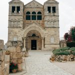 A stone pathway leading toward an ancient building with Mount Tabor rising behind it in the Galilee